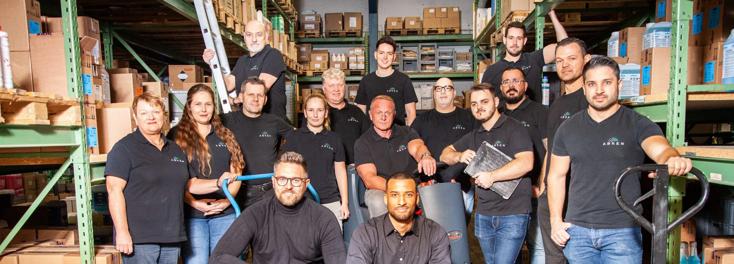 Team von Abken in schwarzer Kleidung in einem Lager mit Reinigungsprodukten und Maschinen