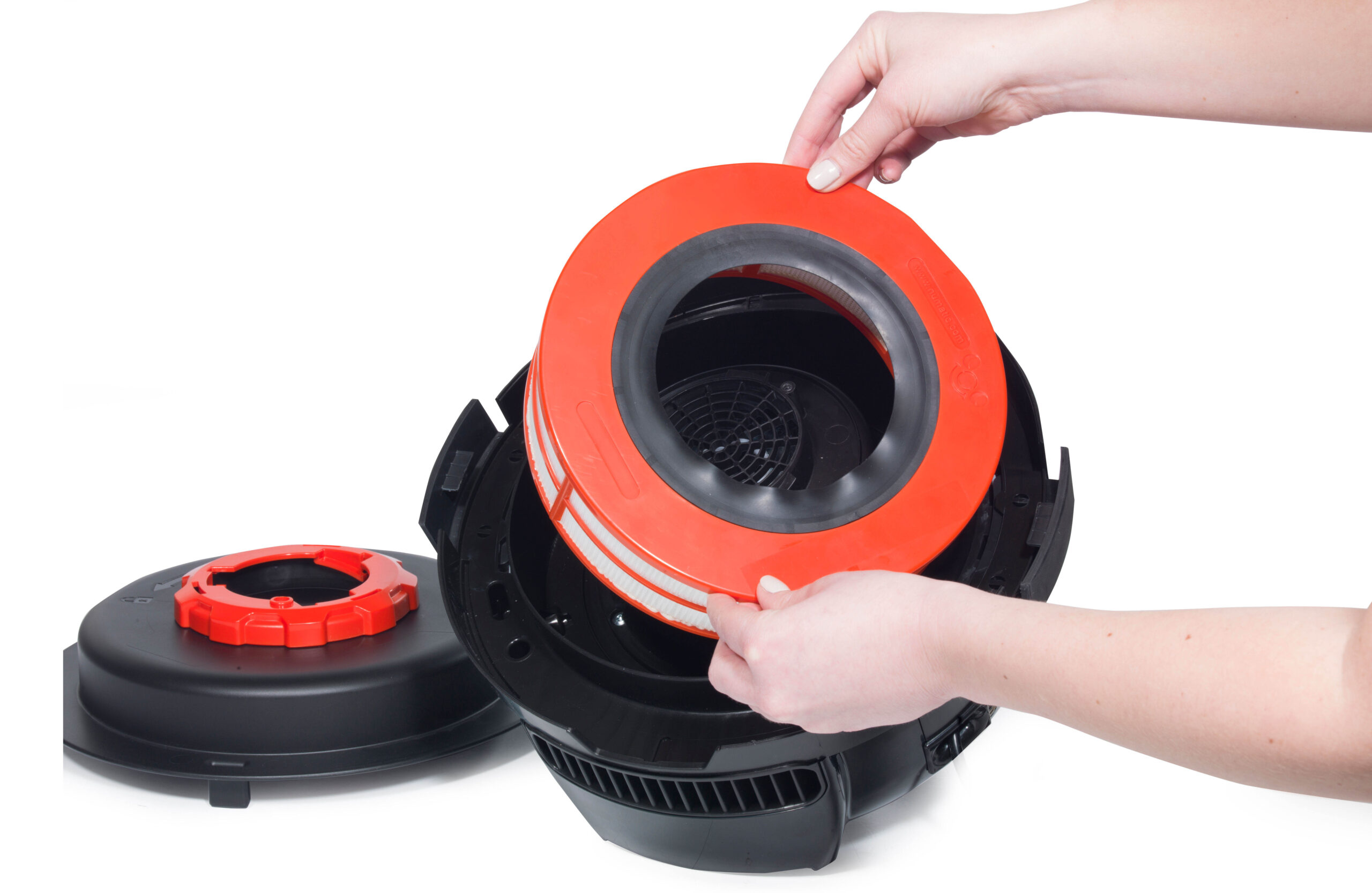 Runder roter Filter, der zur professionellen Reinigung in eine schwarze Staubsaugereinheit eingesetzt wird, mit einem Deckel daneben.