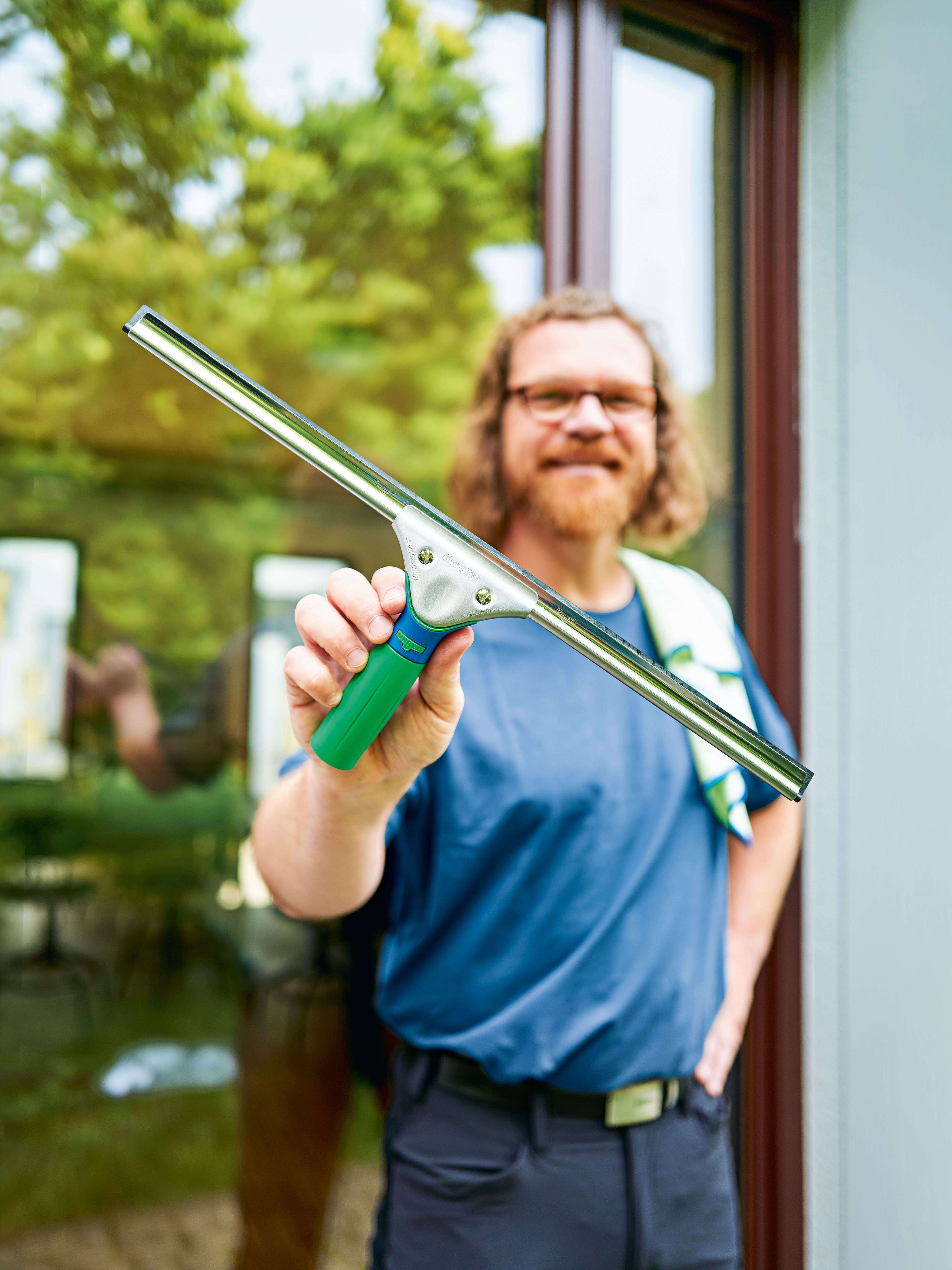 Fensterreinigungsabzieher mit grünem Griff und Metallblende für professionelle Fensterreinigung