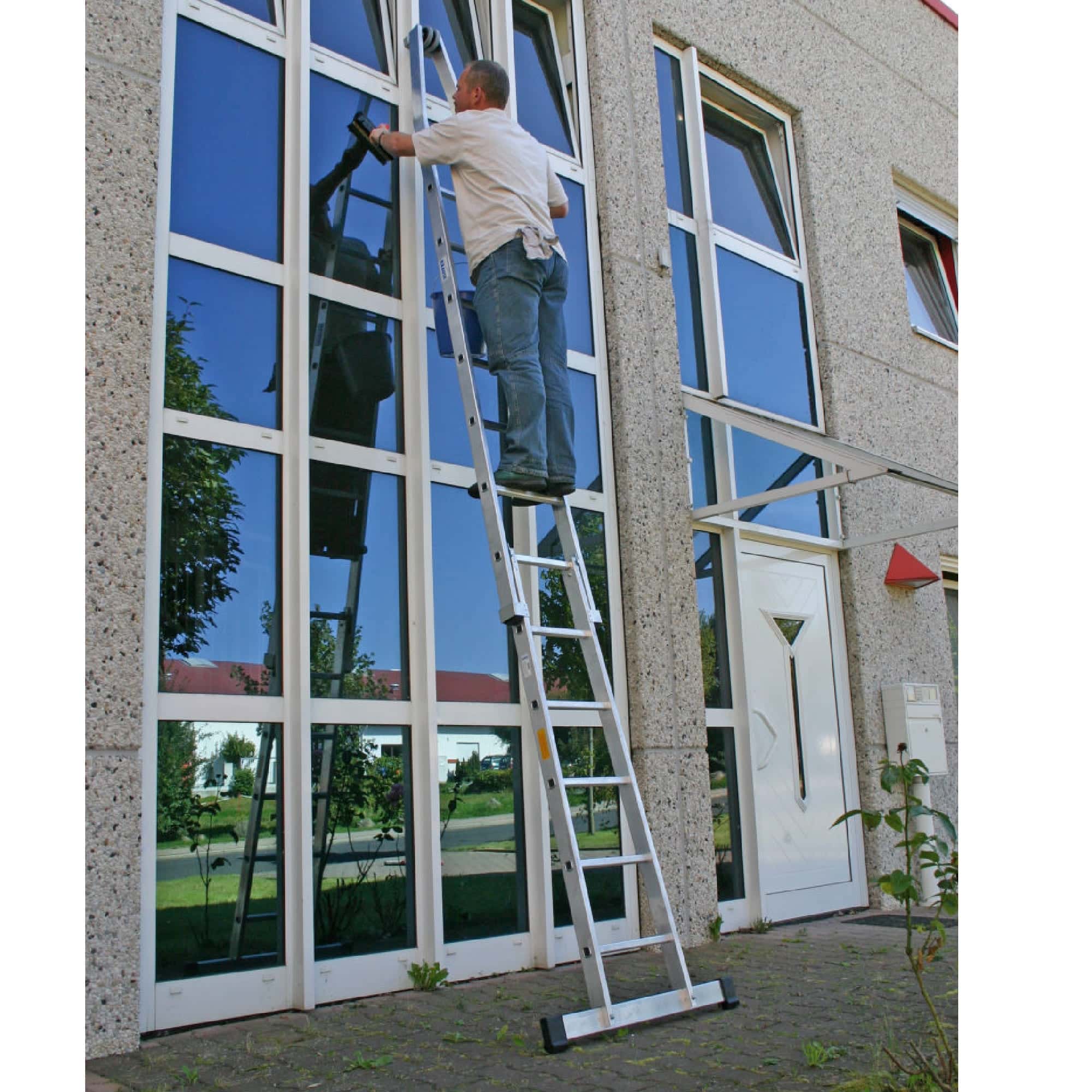 Fensterputzen mit Leiter Mann reinigt Fenster mithilfe einer Leiter vor einem Gebäude.