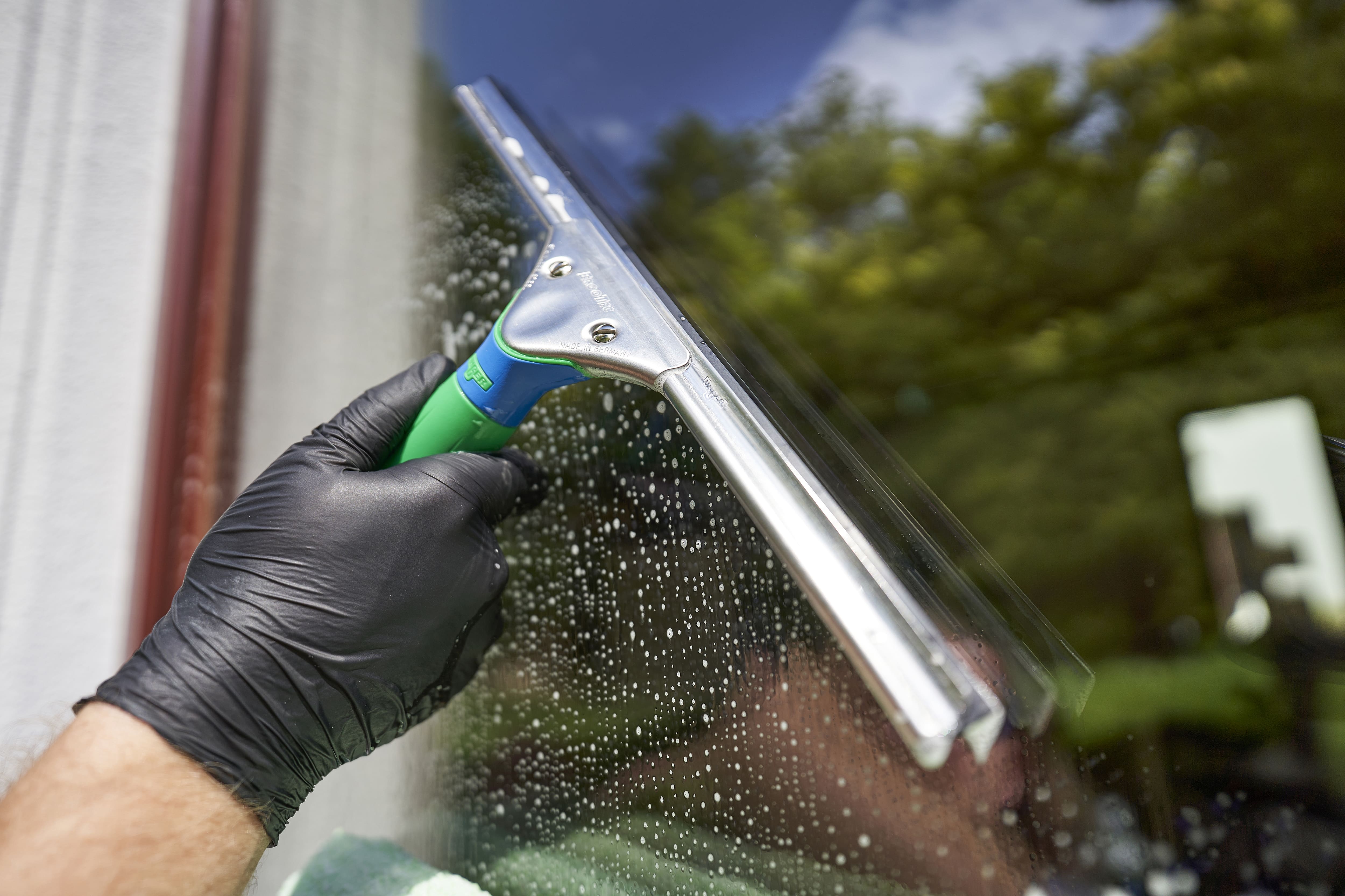 Fensterschaber mit grünem Griff und Edelstahlblatt für die professionelle Fensterreinigung